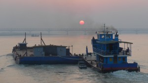 Barge with tug boat with sunrise, Irrawaddy River